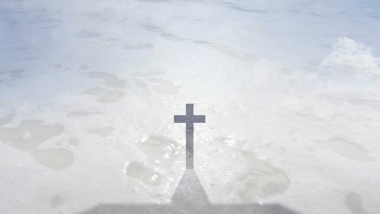Casting shadow on sandy beach, cross with gentle waves in background animation