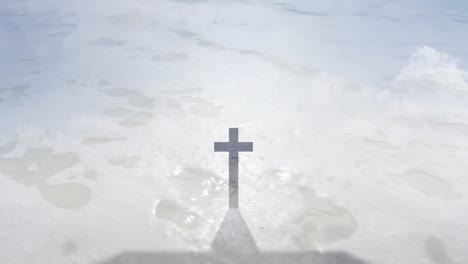 casting shadow on sandy beach, cross with gentle waves in background animation