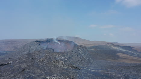 Adelante-Vuelan-Sobre-El-Paisaje-Volcánico-Después-De-La-Erupción.-Suelo-Cubierto-Con-Una-Cálida-Y-Brillante-Capa-De-Lava-Solidificada.-Volcán-Fagradalsfjall.-Islandia,-2021