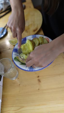 mujer comiendo patatas al horno