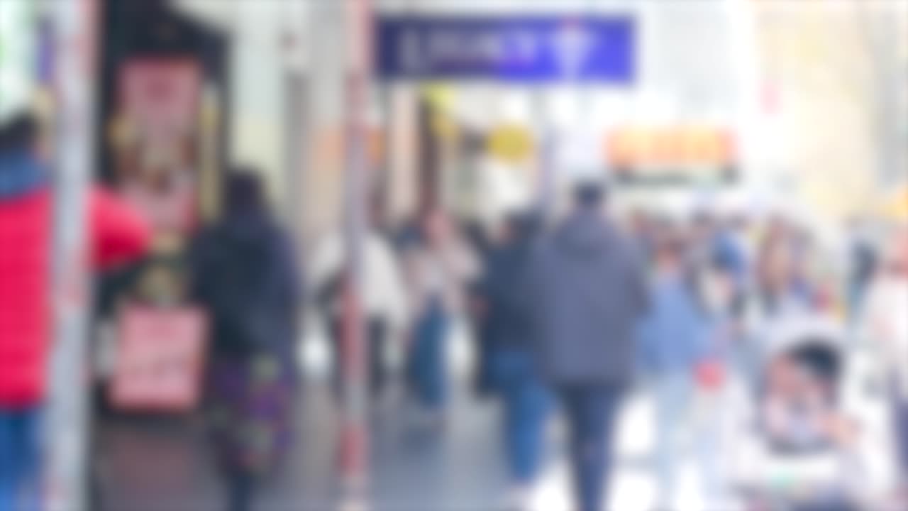 Crowded urban street with diverse pedestrians crossing in bright daylight, showcasing dynamic city life and movement