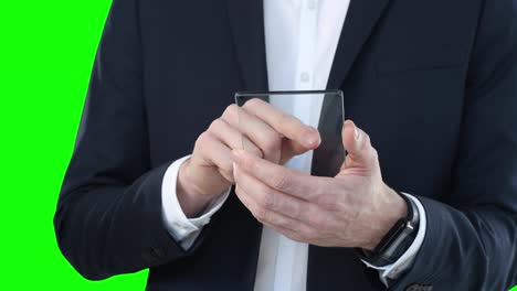 mid section of a caucasian man holding a transparent screen on green background