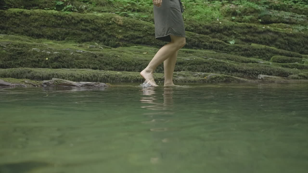 Woman Walking in a Forest Creek