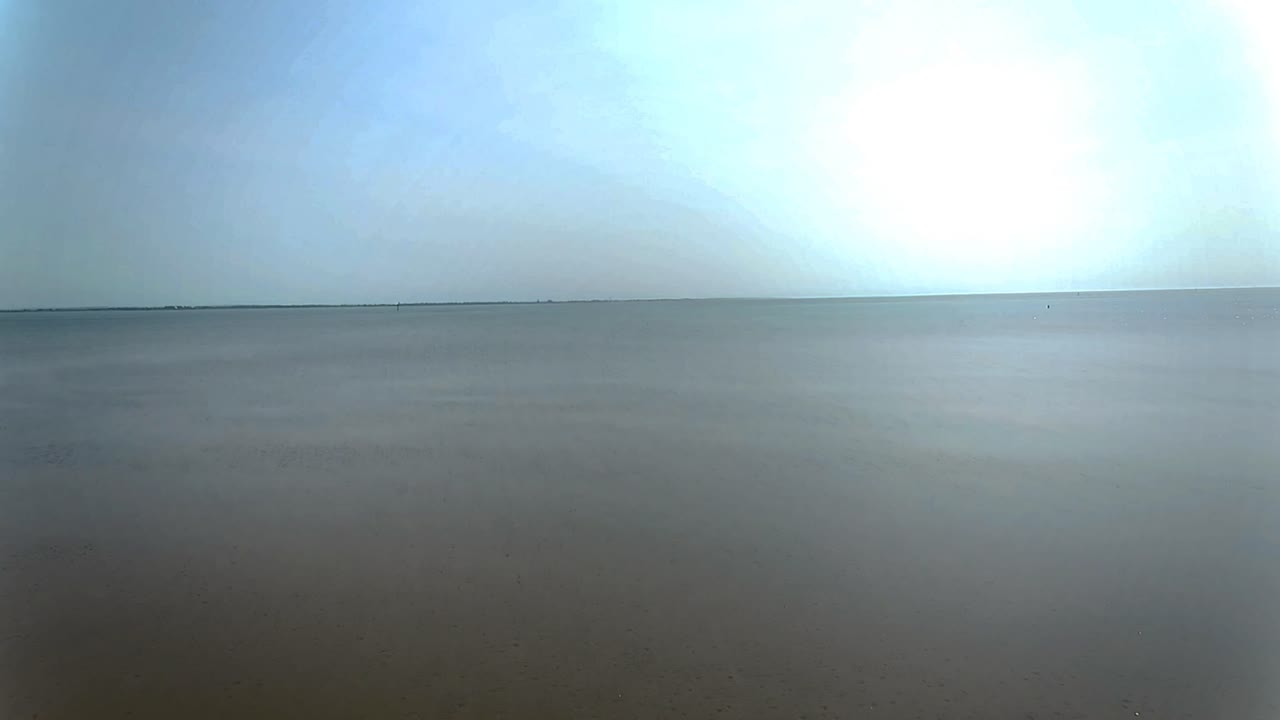 low tide aerial view moving over rippled sand landscape towards seascape skyline