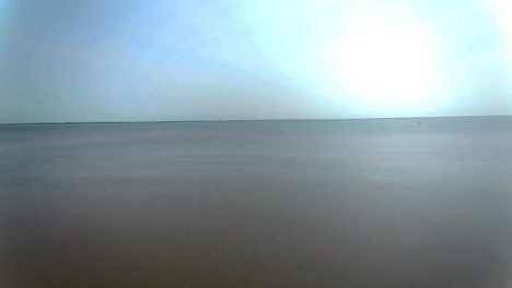 low tide aerial view moving over rippled sand landscape towards seascape skyline