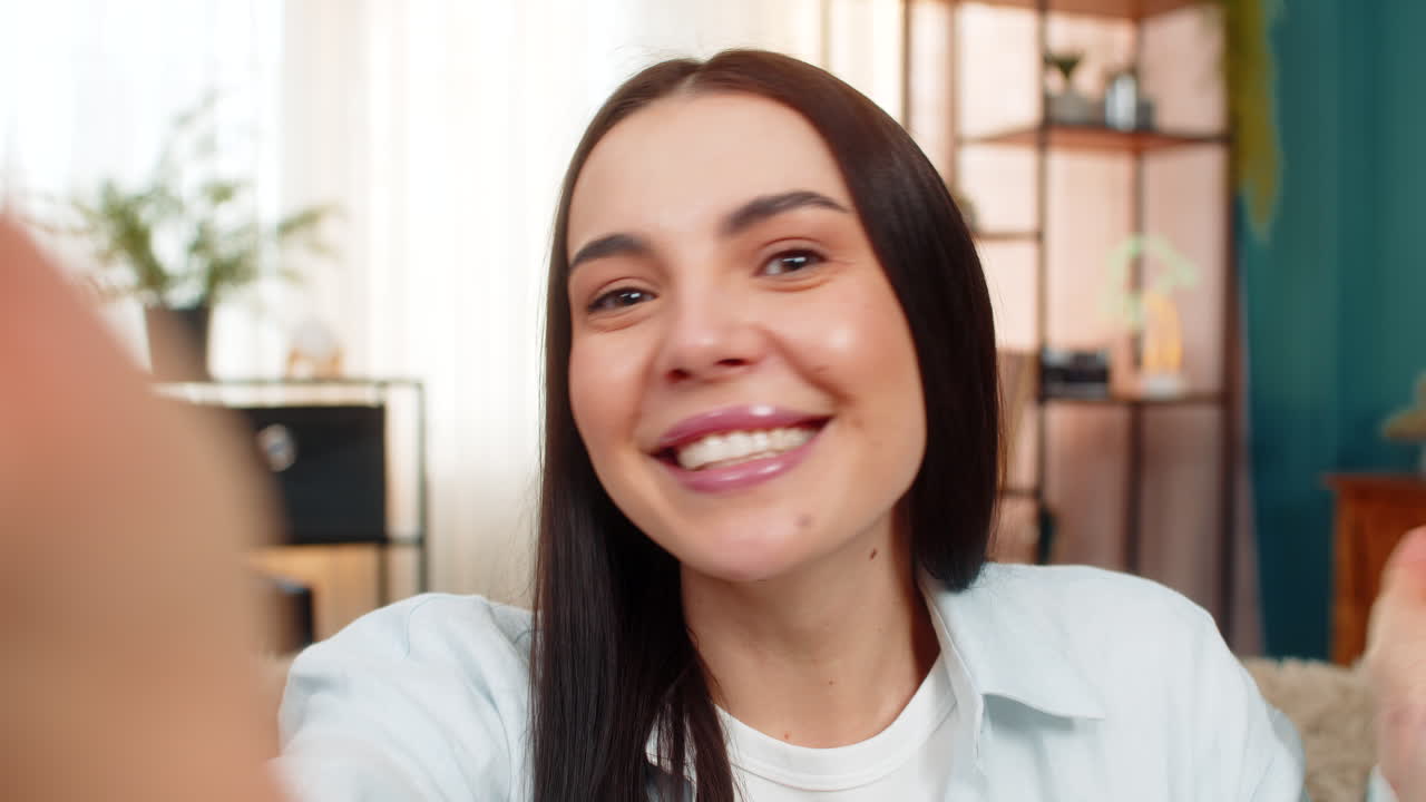 Pov woman smiling and laughing during video call on mobile phone using hands to gesture with emotion