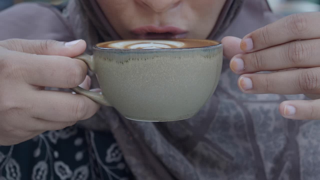 Person holding a cup of coffee with latte art