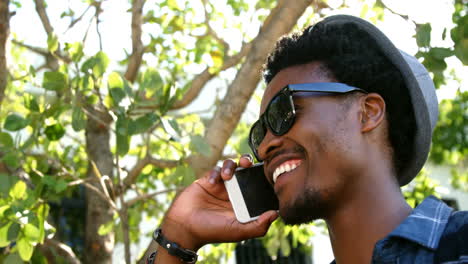 retrato de un joven hipster sonriendo y hablando por teléfono
