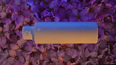 cosmetic packaging on a background of pink almond blossoms, water wave effect