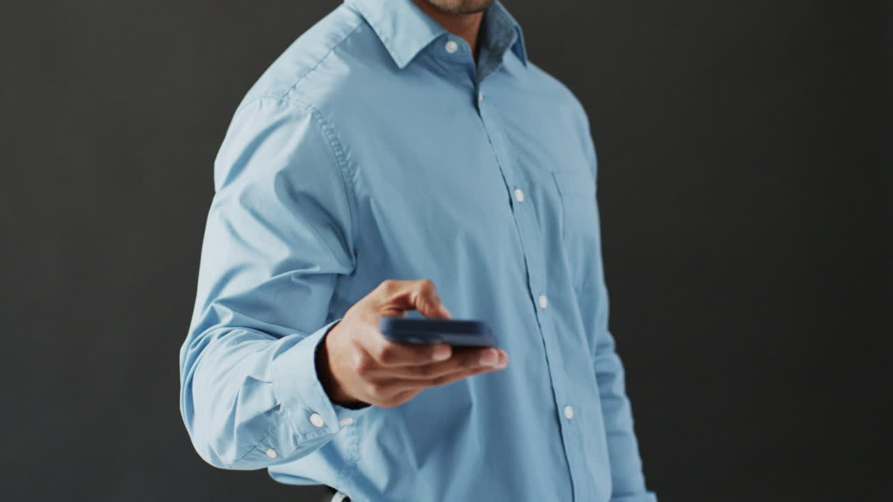 video de un hombre de negocios biracial con un teléfono inteligente y usando una pantalla holográfica, espacio de copia