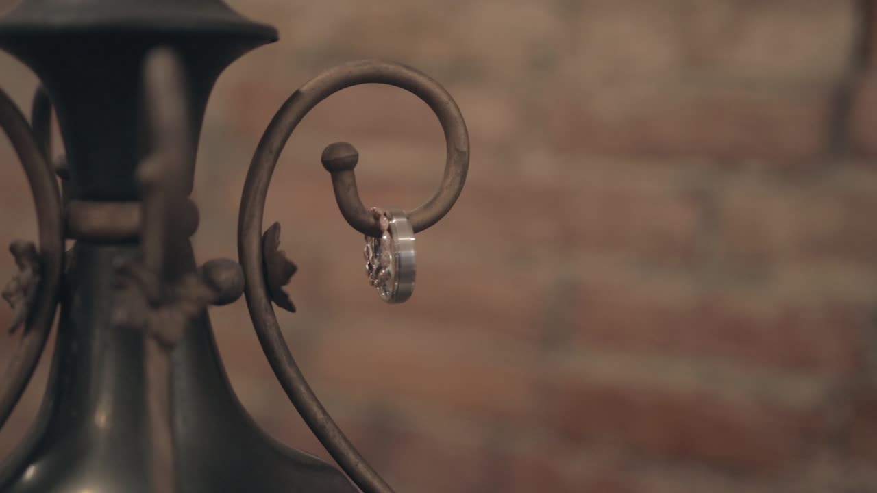 Gold and diamond wedding rings placed on a rustic antique with vintage brick wall background