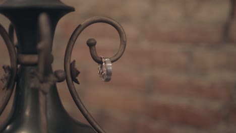 gold and diamond wedding rings placed on a rustic antique with vintage brick wall background