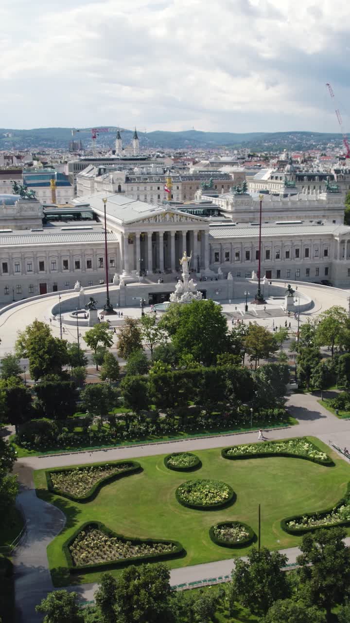 Drone establishing orbit of the Austrian Parliament building with elegant columns and classical design, clean sleek white walls. Vertical Shot