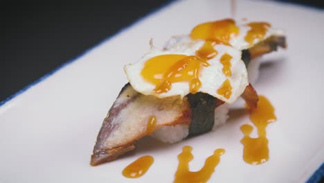 sauce spilling on sushi with fried eggs