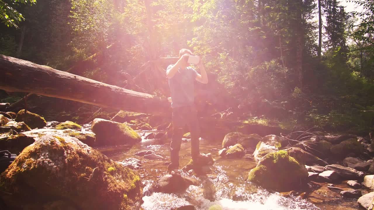 Man exploring a forest stream with VR headset