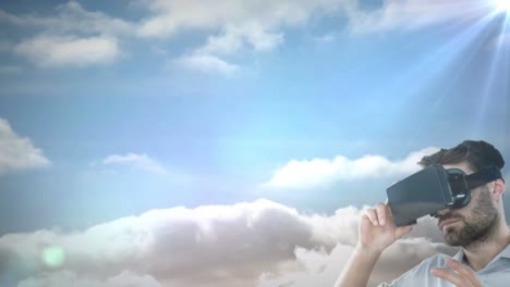 Caucasian-man-wearing-vr-headset-against-spot-of-light-and-clouds-in-the-sky