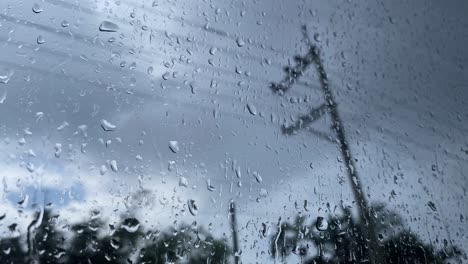 Primer-Plano-De-Las-Gotas-De-Agua-De-Lluvia-Que-Gotean-Sobre-La-Superficie-De-La-Ventana-En-Un-Día-Nublado-Sombrío