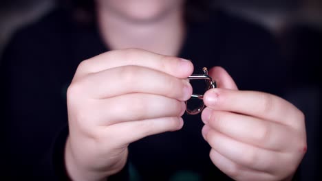 4k of child hands playing with metal puzzle for brain teaser