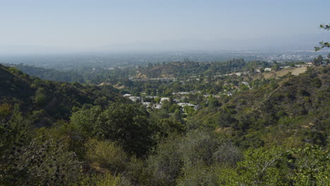 Descending-shot-of-valley-with-houses-spotted-in-the-middle-located-in-Hollywood-Hills-Southern-California