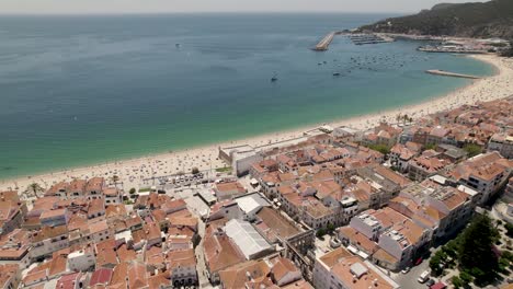 vista aérea del paisaje marino de la playa de sesimbra llena de turistas vistos desde la ciudad, portugal