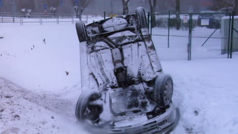 crashed car upside down on the roof after an accident on winter road with snow