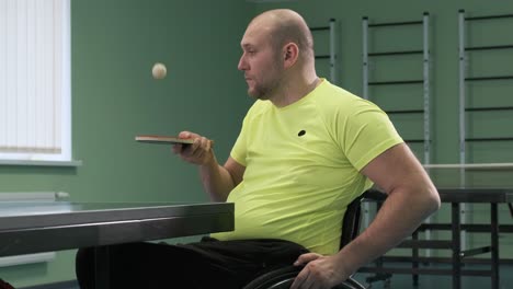 a man in a wheelchair plays ping pong. people with disabilities play table tennis. rehabilitation of the disabled. sport.