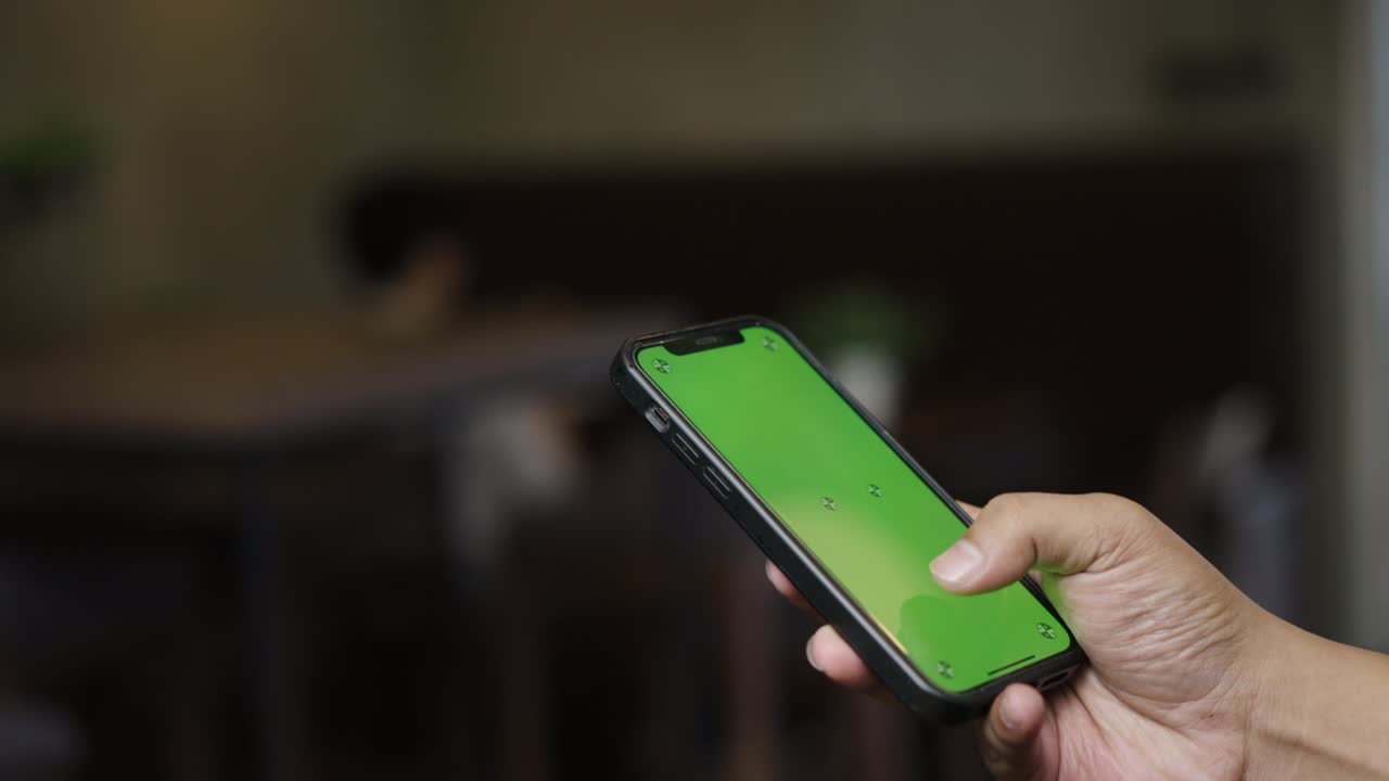Uomo che usa lo smartphone in modalità verticale con schermo mock-up verde