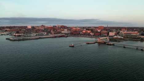 Luftaufnahmen-über-Die-Skyline-Und-Die-Uferpromenade-Von-Portland-Maine-Vom-Wasser-Aus-Bei-Sonnenaufgang