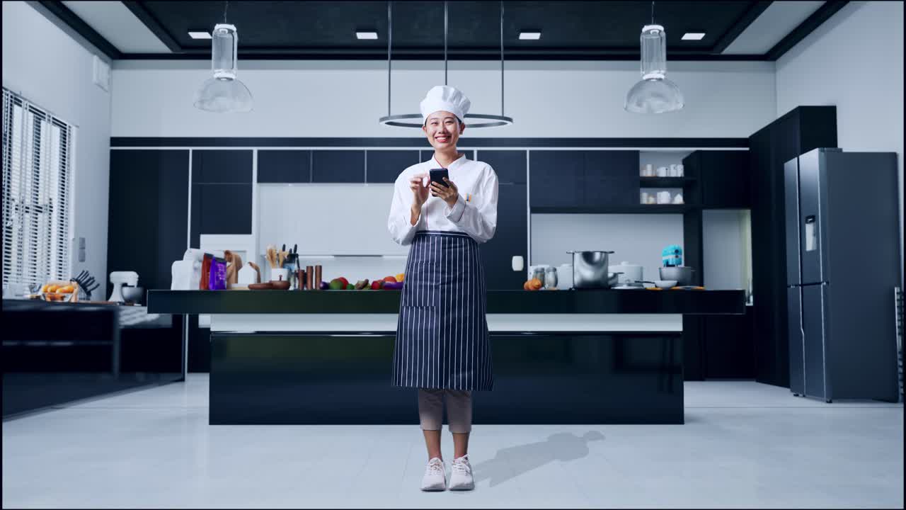 Chef che usa uno smartphone in una cucina moderna.
