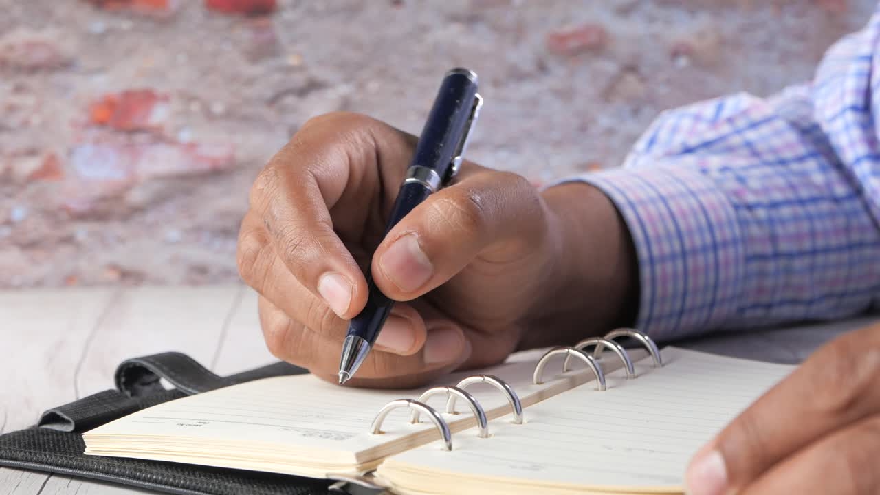 Person Writing in a Notebook