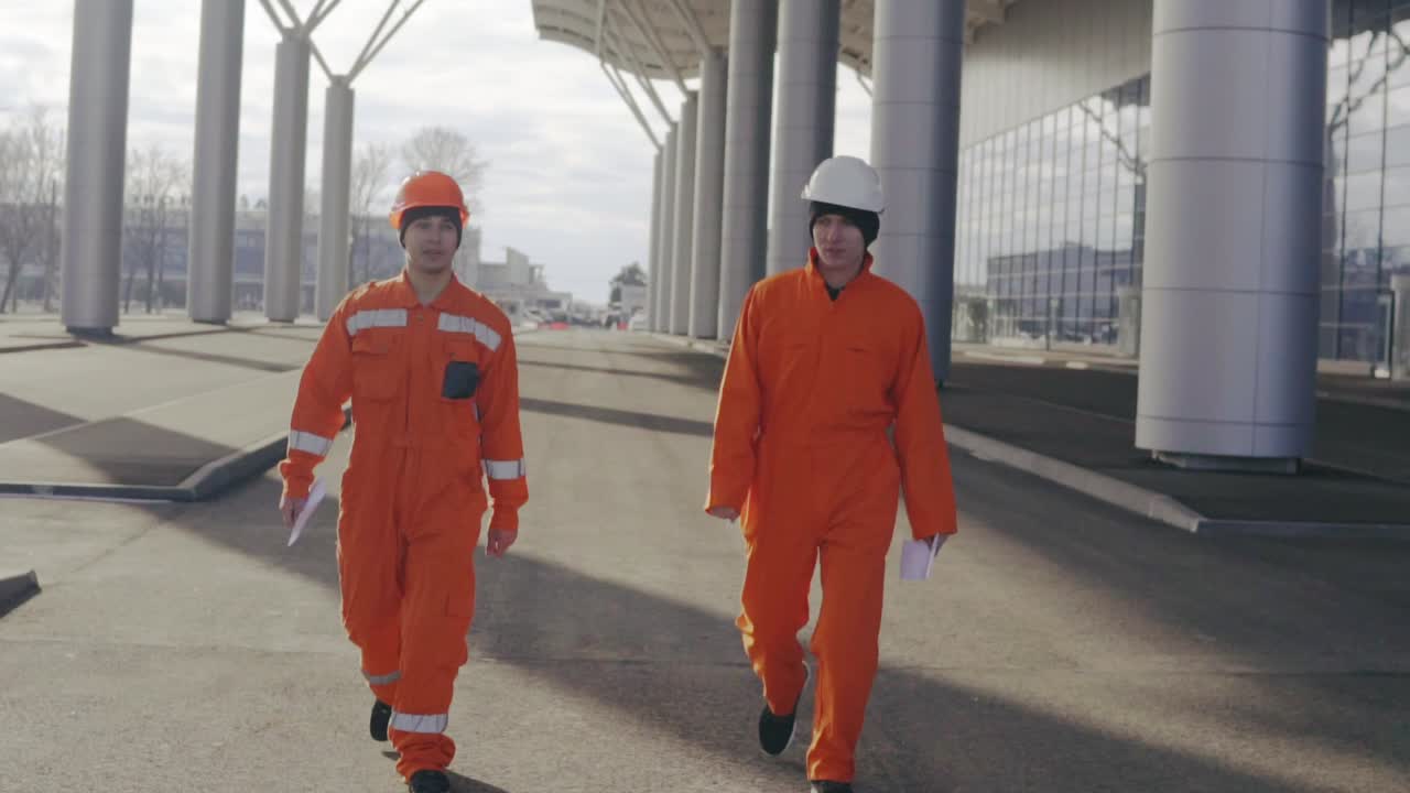 dos trabajadores de la construcción felices caminando y saltando juntos