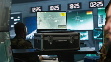 military expert in base of operations using radar on notebook