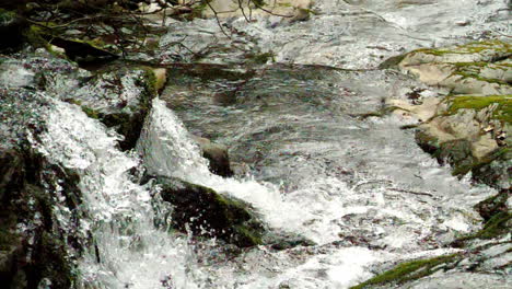 two small waterfalls plunge water shot in slow motion at 180 frames per second