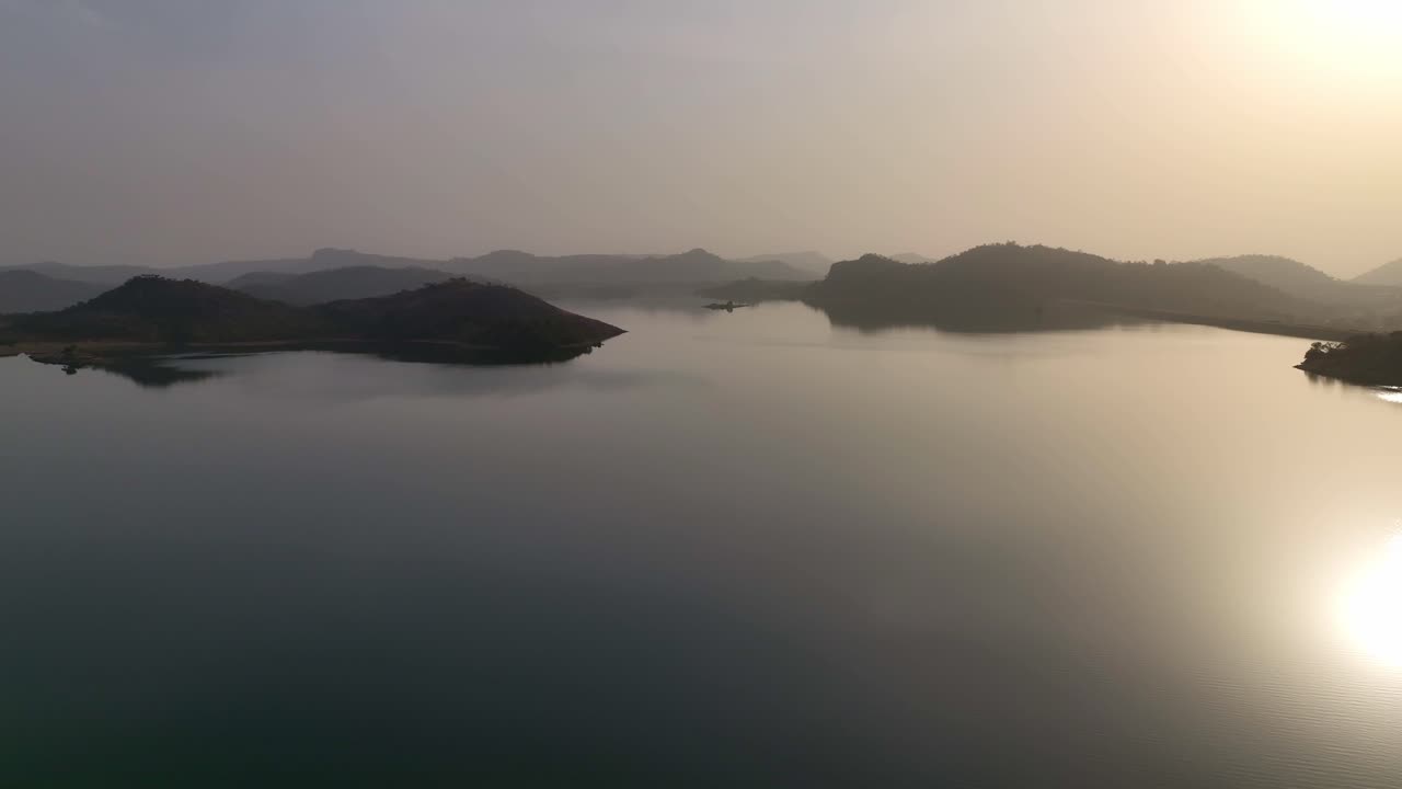 공중 - 암석 노두가 있는 호수의 멋진 일몰, 전방 드론 샷