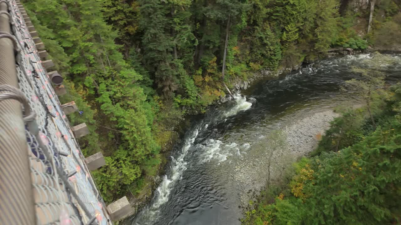 Gimbal wide panning shot of the Capilano River as seen from a suspension bridge in North Vancouver, British Columbia, Canada. 4K at 30 FPS