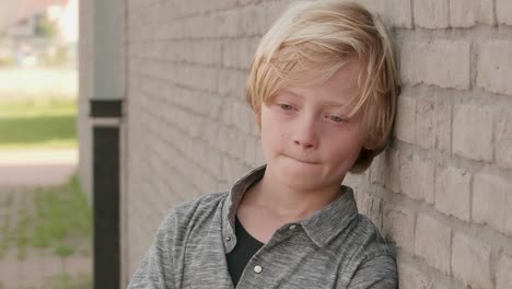 sad, adorable, cute, little boy standing at wall, almost crying