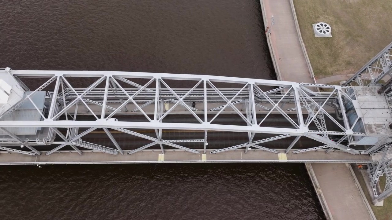 Top down of historic Duluth Aerial Lift Bridge towers with cars and vehicle traffic travelling over shipping canal