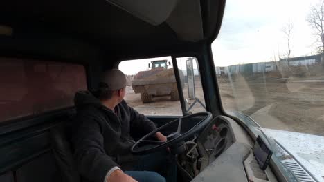 1972-dump-truck-being-loaded-with-dirt-while-driver-sits-inside,-interior-view