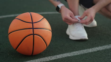 basketball player tying shoes on court