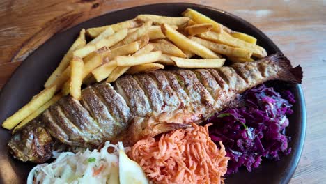 baked trout served with mixed salads, fries and lemon