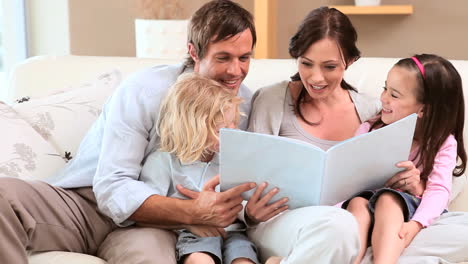 smiling family reading a book together