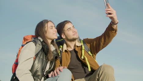 happy couple taking selfie while kissing