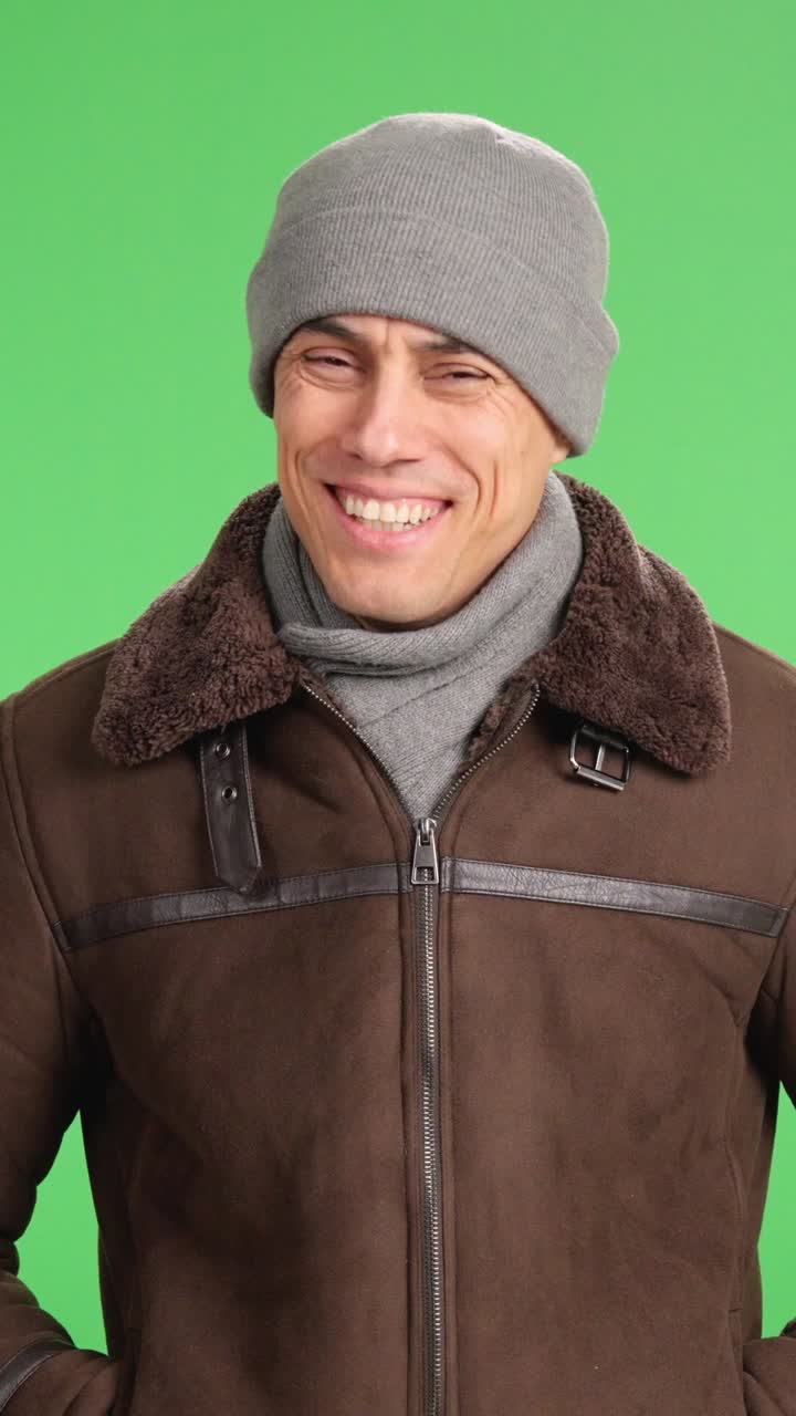Smiling man wearing winter clothes on green screen background