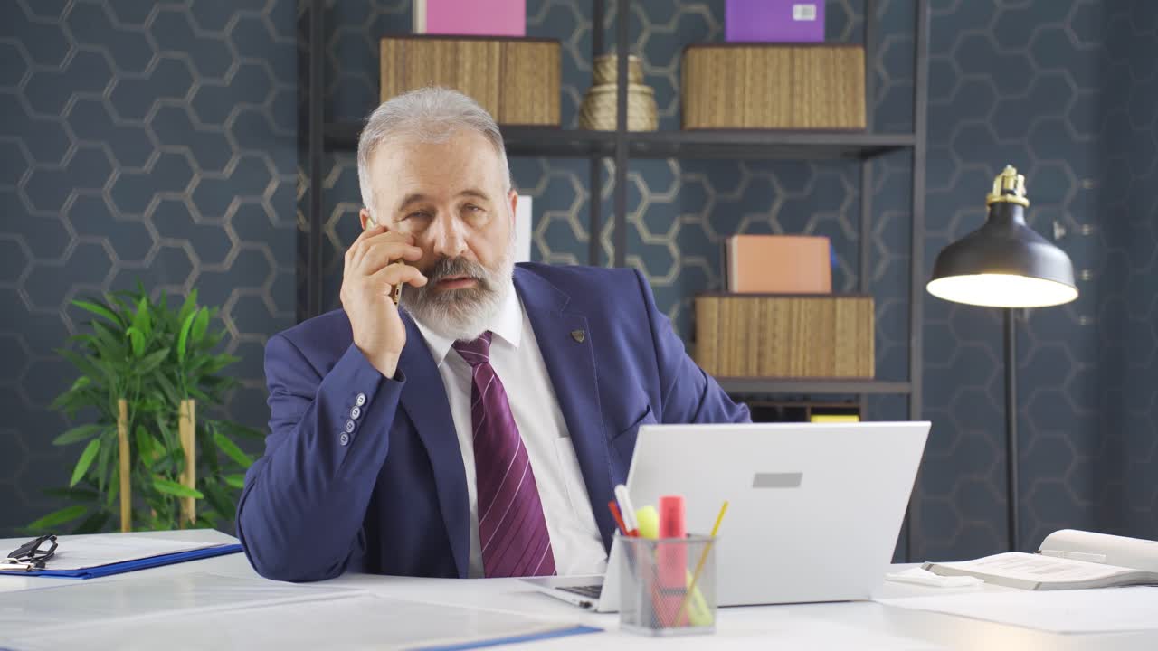 공격적인 사업가가 화를 내며 전화로 이야기하고 있습니다.