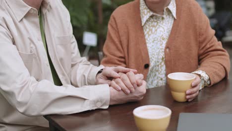 Älteres-Paar-Hält-Händchen,-Während-Es-Draußen-Eine-Tasse-Kaffee-Trinkt,-Romantik-Liebes-Unterstützungskonzept