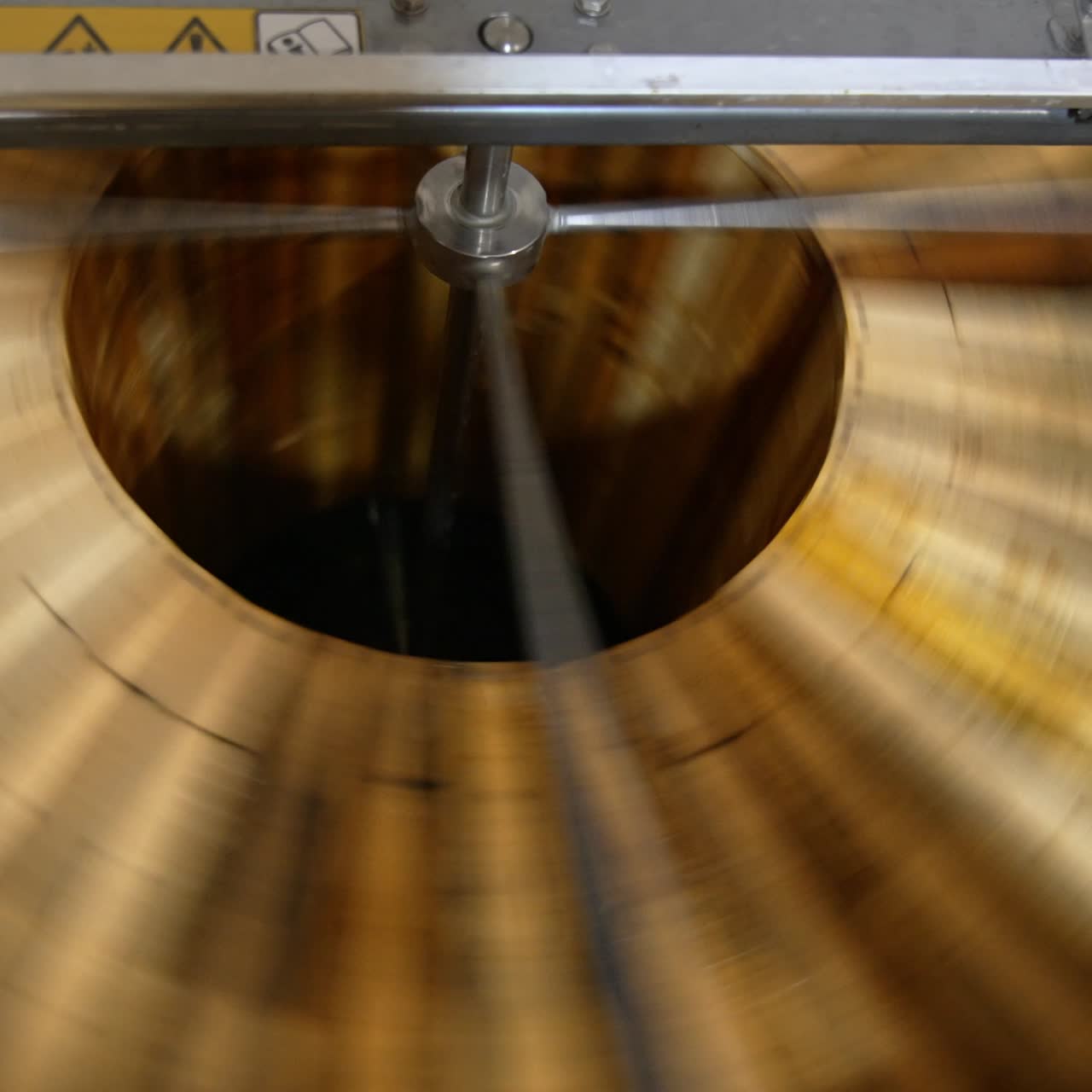 Quick spinning of honey frames in the automatic machine. Wooden honey frames are rotated to remove fresh organic honey from them