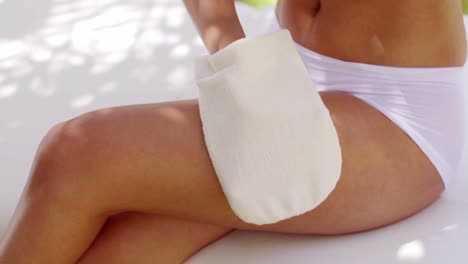 young woman buffing her skin with a glove