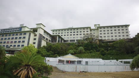 resort hotel closed and abandoned on seaside, dark overcast day establishing shot