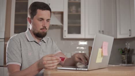 hombre pagando facturas en línea usando una computadora portátil