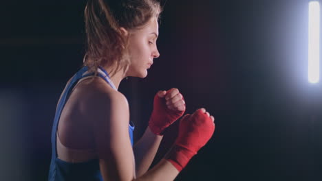 Boxeadora-Entrenando-En-Una-Habitación-Oscura-Con-Luz-De-Fondo-En-Vista-Lateral-En-Cámara-Lenta.-Disparo-De-Cámara-Steadicam